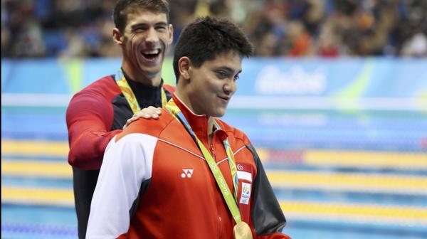 Michael Phelps sonríe con su medalla plateada ante un incrédulo Joseph Schooling (Reuters)