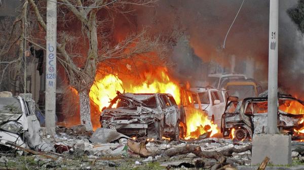 Un auto arde en llamas tras el ataque contra el hotel Ambassador, en Somalia (AFP)