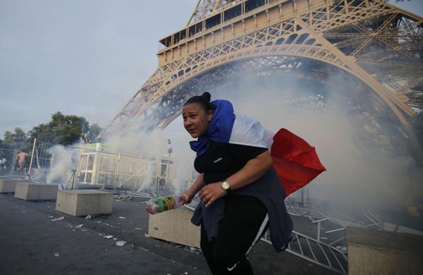 Una fanática francesa en medio de los disturbios, el pie de la Torre Eiffel (Reuters)