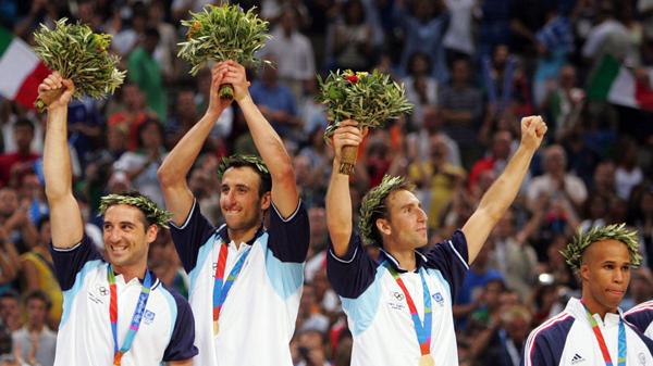 El seleccionado argentino de basquet celebra la obtención de la medalla de oro y la simbólica corona y ramo de olivos. (Reuters)