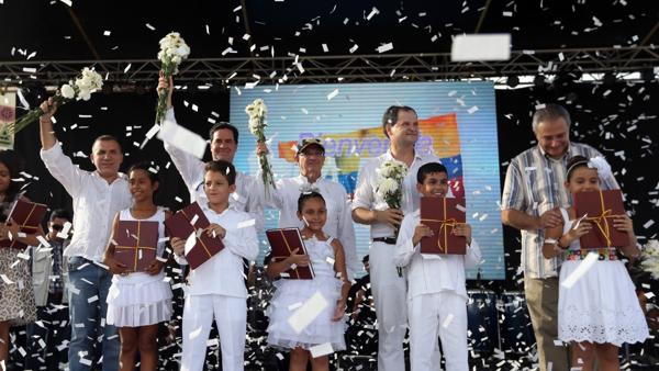 El jefe de la delegación del gobierno de Colombia en las negociaciones, Humberto de la Calle, posa con niños y copias del acuerdo de paz (AP)