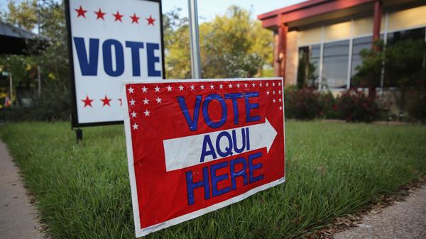 Carteles bilingües que se veían este año en los centros de votación para las primarias presidenciales (Getty Images)