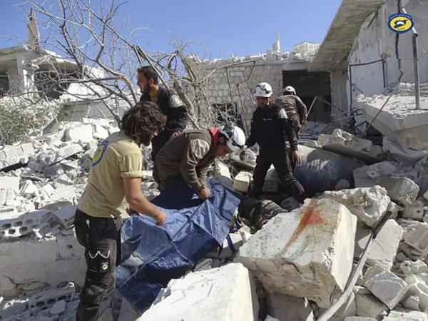 Rescatistas buscan entre los escombros provocados por los bombaerdeos en Hass (Syrian Civil Defense White Helmets via AP)