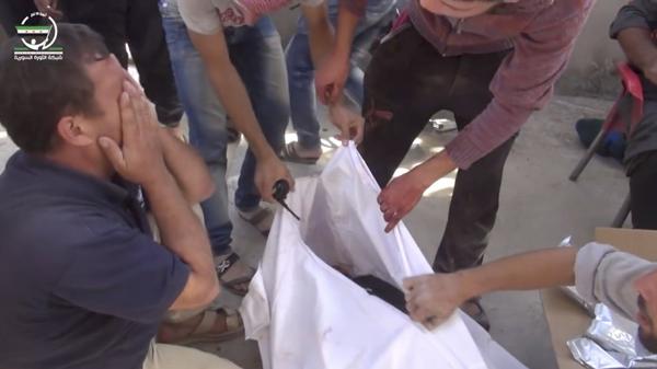 Un hombre llora cerca de un cuerpo después del bombardeo en Hass, Siria (Muaz al-Shami, Syrian Revolution Network, via AP)
