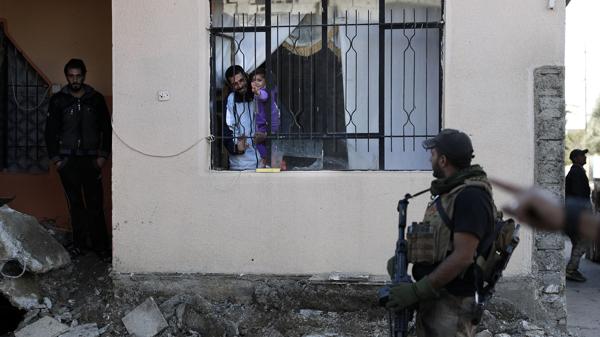 Civiles saludan a los soldados de las fuerzas especiales iraquíes después de la liberación del barrio de Adén, en Mosul (AFP)