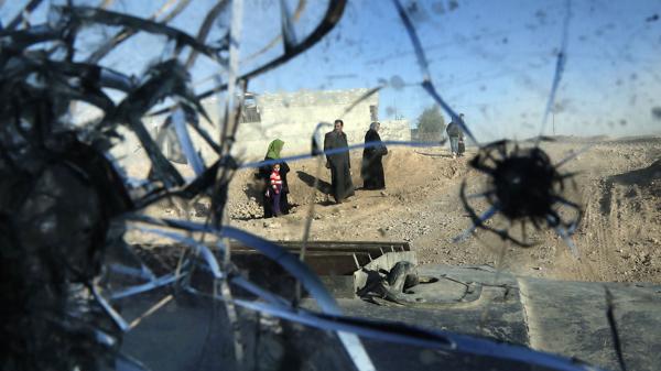 Residentes del distrito de Adén, en Mosul, vistos a través del parabrisas acribillado de un vehículo blindado de las Fuerzas Especiales iraquíes (AFP)