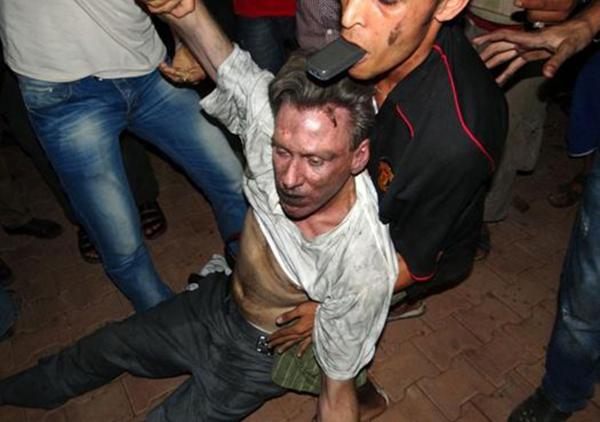 Una turba enardecida traslada a Stevens fuera de la embajada norteamericana en Libia. Lo asesinarían minutos después