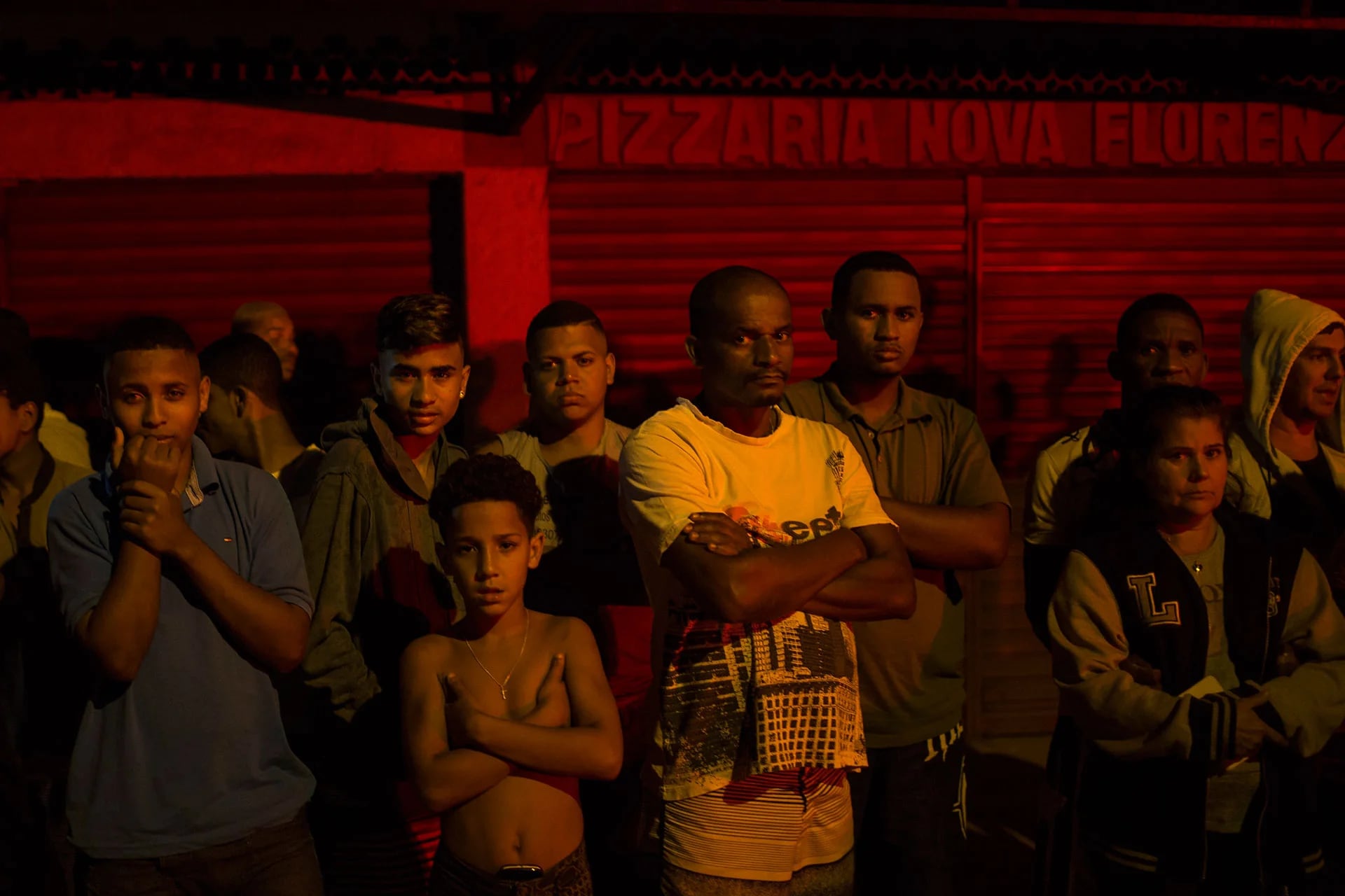 Los residentes de una favela observan cómo retiran el cuerpo de un joven asesinado (AP)