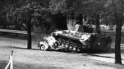 Una de las imágenes icónicas de la recuperación del regimiento de La Tablada: un tanque pasa por encima de uno de los vehículos con que ingresaron los subversivos del MTP