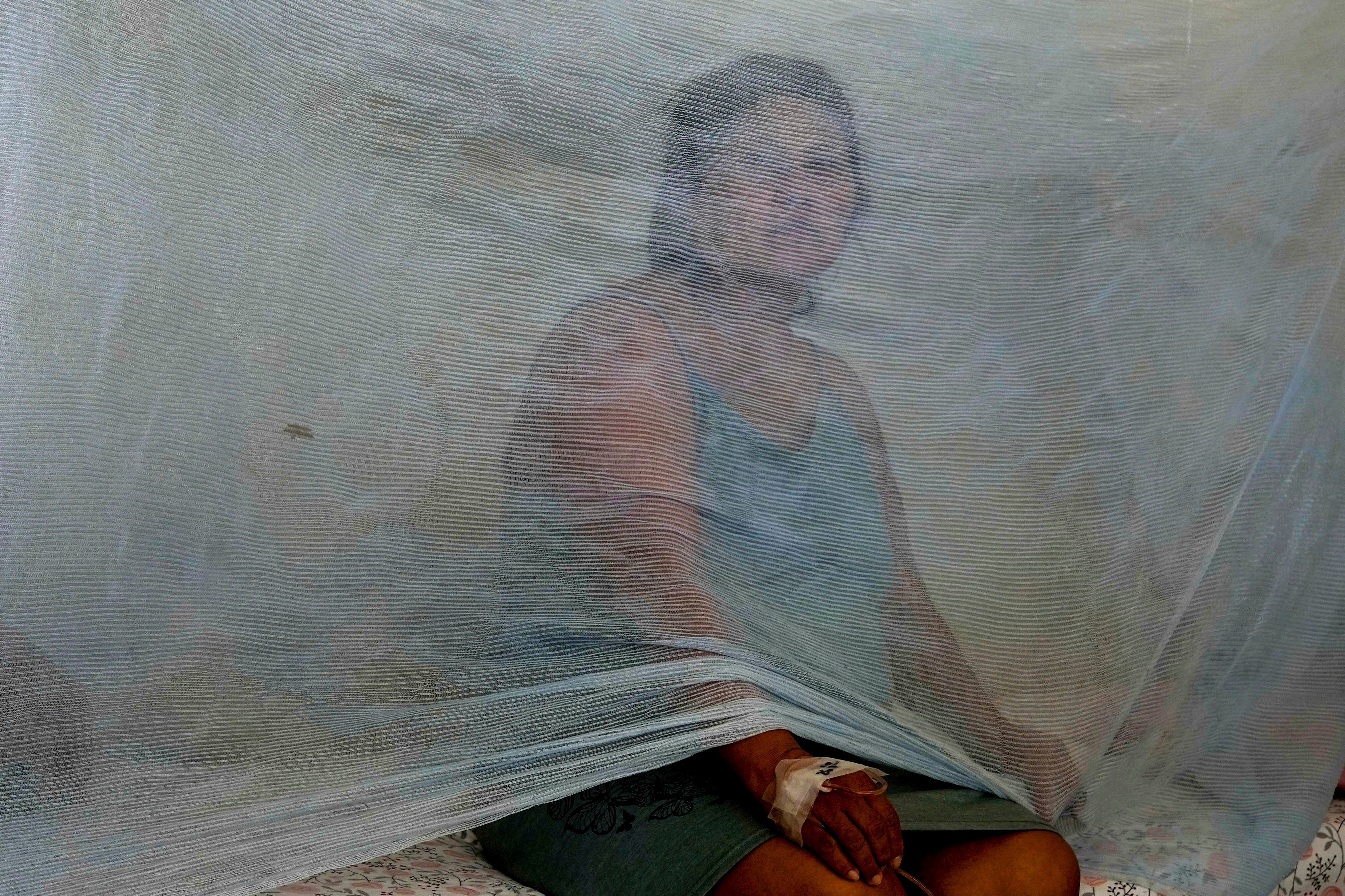 Jenny Chiroque, infectada con dengue, sentada en una cama en el hospital de La Merced en Paita, Perú, el jueves 29 de febrero de 2024. Perú declaró la emergencia de salud en la mayoría de sus regiones el 26 de febrero ante el aumento de casos de dengue. (AP Foto/Martín Mejía)