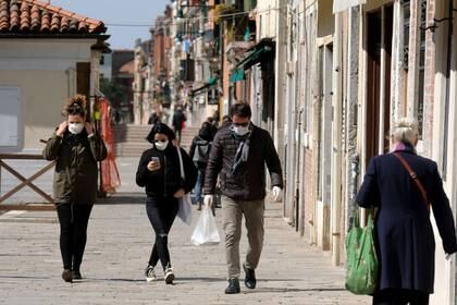 Ciudadanos usan máscaras protectoras en las calles de Venecia durante la actual emergencia por la enfermedad COVID-19 (REUTERS/Manuel Silvestri)