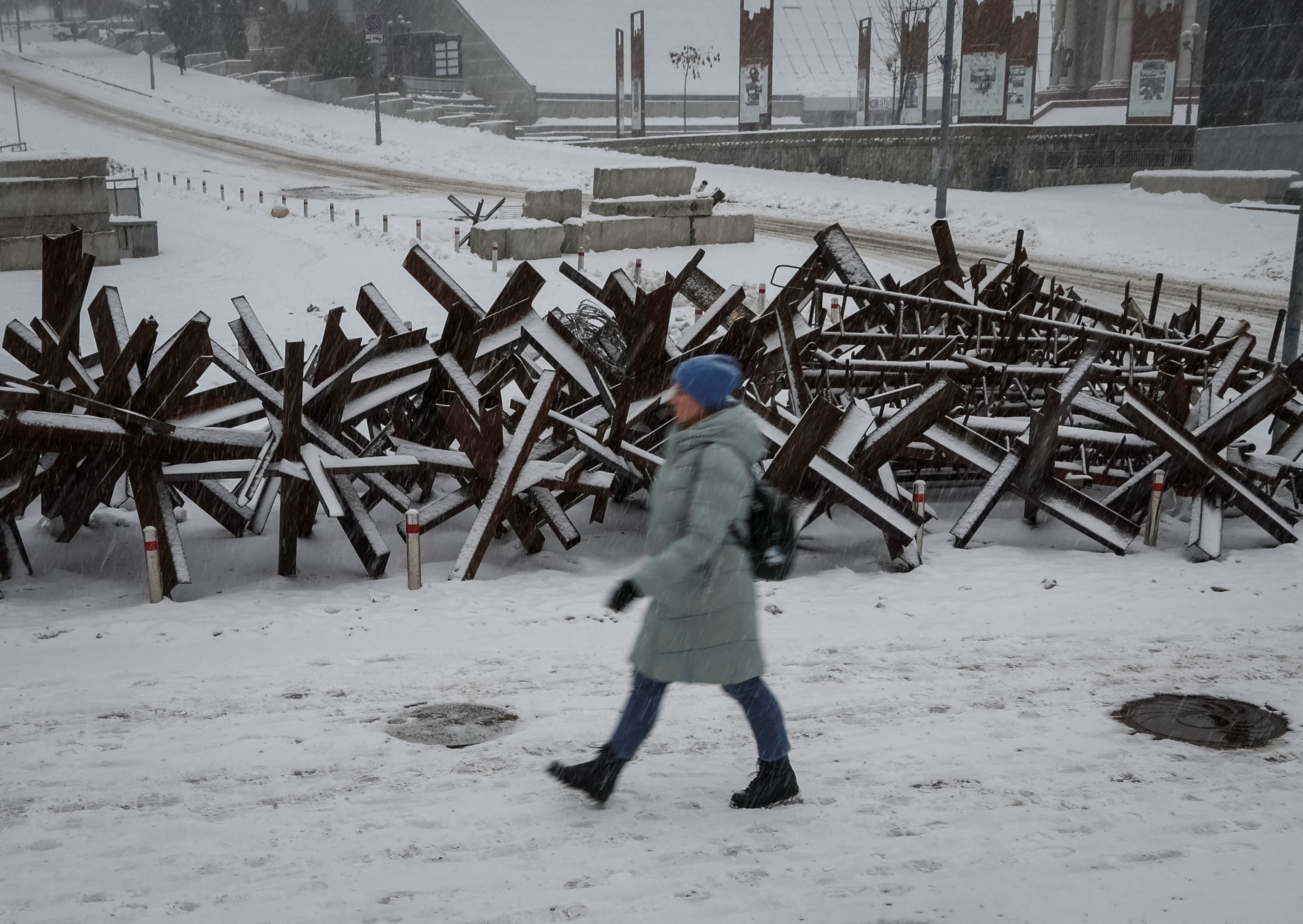 Una mujer camina por una calle cerca de construcciones antitanque en el centro de Kiev (REUTERS/Gleb Garanich)
