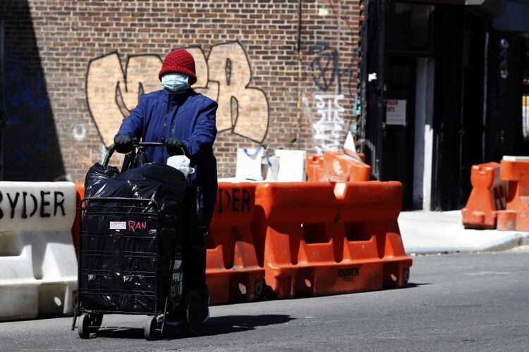 Una mujer camina arrastrando un carro por la Avenida Roosevelt de Queens (REUTERS/Stefan Jeremiah)