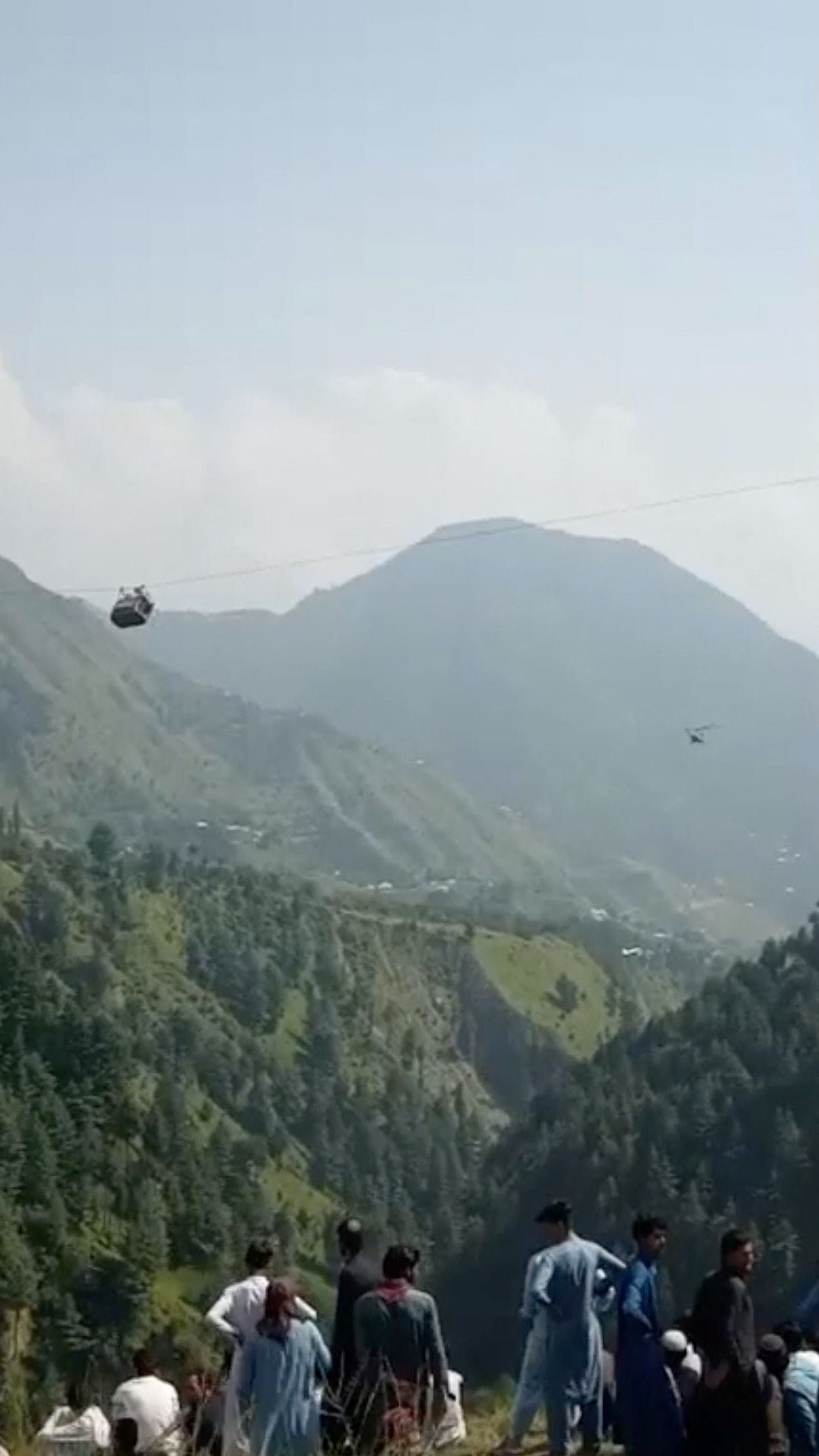 Una vista muestra un helicóptero que realiza una operación de rescate junto al teleférico con estudiantes varados en el aire en Battagram, Pakistán, el 22 de agosto de 2023, en esta captura de pantalla obtenida de un video de las redes sociales. Umeed Sahar/a través de REUTERS
