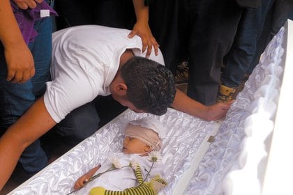 Nelsón Lorío llora ante el cadáver de su hijo. (Cortesía La Prensa)
