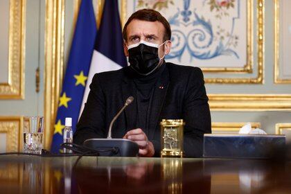 French President Emmanuel Macron, wearing a protective face mask, attends a video-conference meeting with World Health Organization (WHO) Director-General Tedros Adhanom Ghebreyesus at the Elysee palace in Paris amid the coronavirus disease (COVID-19) outbreak, France, February 8, 2021.  REUTERS/Christian Hartmann/Pool