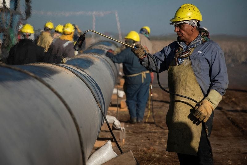FOTO DE ARCHIVO Personas trabajan durante la construcción del gasoducto Néstor Kirchner para transportar gas natural desde la formación Vaca Muerta en el oeste argentino (REUTERS/Martin Cossarini)