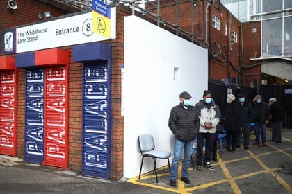 Personas hacen cola mientras esperan recibir la vacuna contra el COVID-19 en el Centro de Vacunación del Crystal Palace Football Club en Londres, el 4 de febrero de 2021 (REUTERS/Hannah McKay)