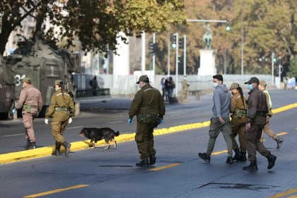 Agentes de policía detienen a un hombre sin acreditación de circulación mientras los ayuntamientos locales han aumentado las restricciones de cierre durante el brote de la enfermedad del coronavirus (COVID-19), en Santiago, Chile, el 25 de marzo de 2021. REUTERS/Ivan Alvarado