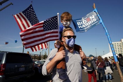 Un hombre con su hijo festejan la victoria de Joe Biden en Wilmington, Delaware.  REUTERS/Kevin Lamarque