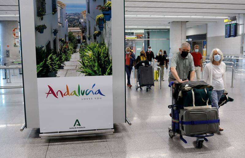Imagen de archivo de turistas con mascarillas caminando con sus maletas por el Aeropuerto de Málaga-Costa del Sol en Málaga, Andalucía, España. 24 mayo 2021. REUTERS/Jon Nazca