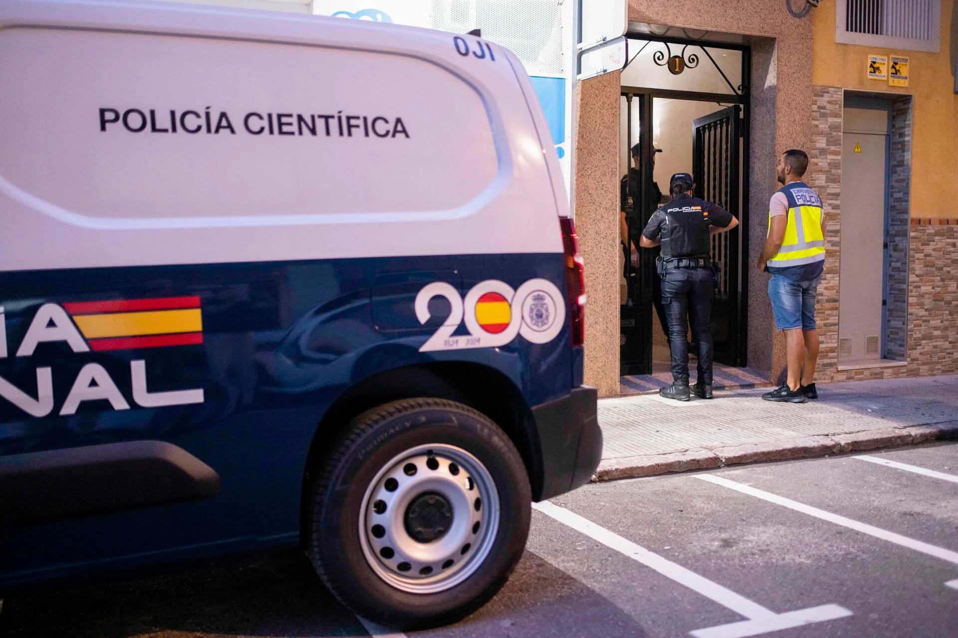 Un equipo de Policía Científica en la puerta del inmueble de Castellón donde han sido hallados los cadáveres de una mujer junto al de su pareja, un hombre que se había ahorcado, y que se investiga como un posible caso de violencia de género. (EFE/ Andreu Esteban)