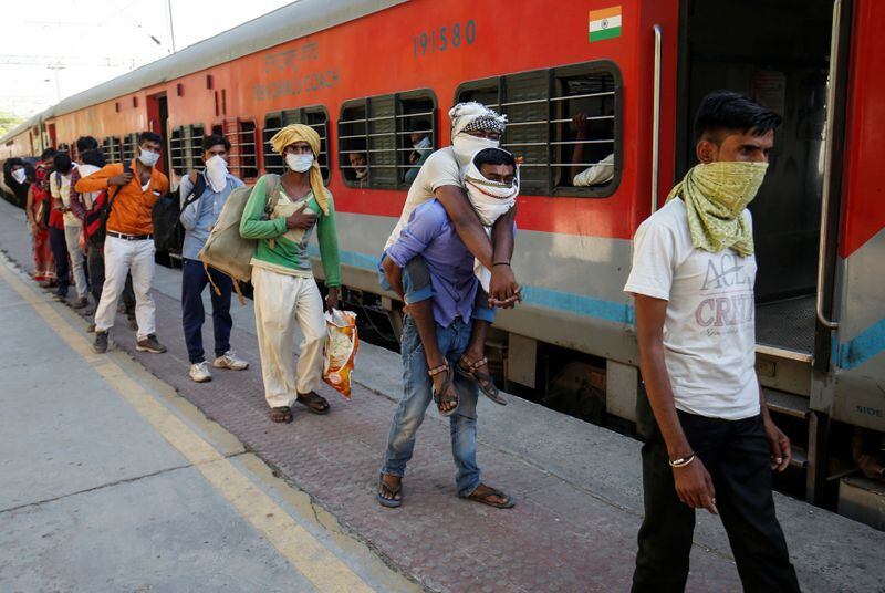 Trabajadores migrantes, que quedaron varados en el estado occidental de Gujarat debido a un bloqueo impuesto por el gobierno para prevenir la propagación de la enfermedad coronavirus (COVID-19), esperan para abordar un tren en una estación de ferrocarril para salir hacia su estado natal de Uttar Pradesh, en Ahmedabad, India. 2 de mayo de 2020. REUTERS/Amit Dave