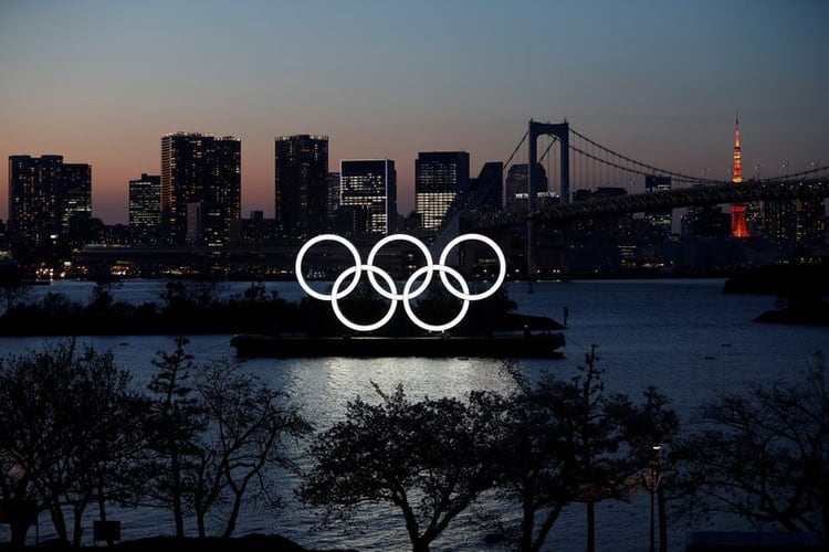 Anillos olímpicos gigantes se ven al anochecer en el área costera del Parque Marino de Odaiba, en Tokio. 25 de marzo de 2020. REUTERS/Issei Kato