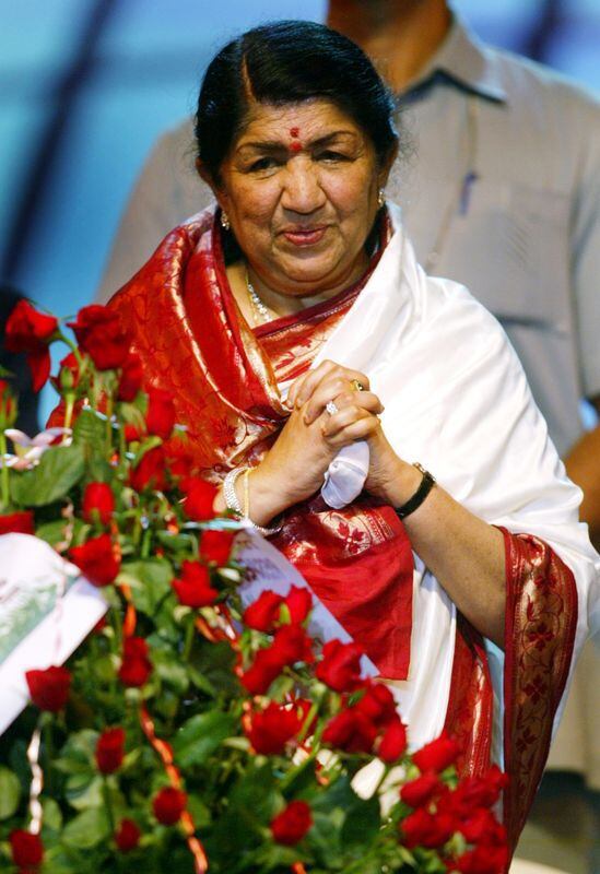 La cantante de Bollywood Lata Mangeshkar mira un ramo que recibió en su 75 cumpleaños durante una celebración en Bombay Septiembre
28 de enero de 2003. REUTERS/Sherwin Crasto/Foto de archivo