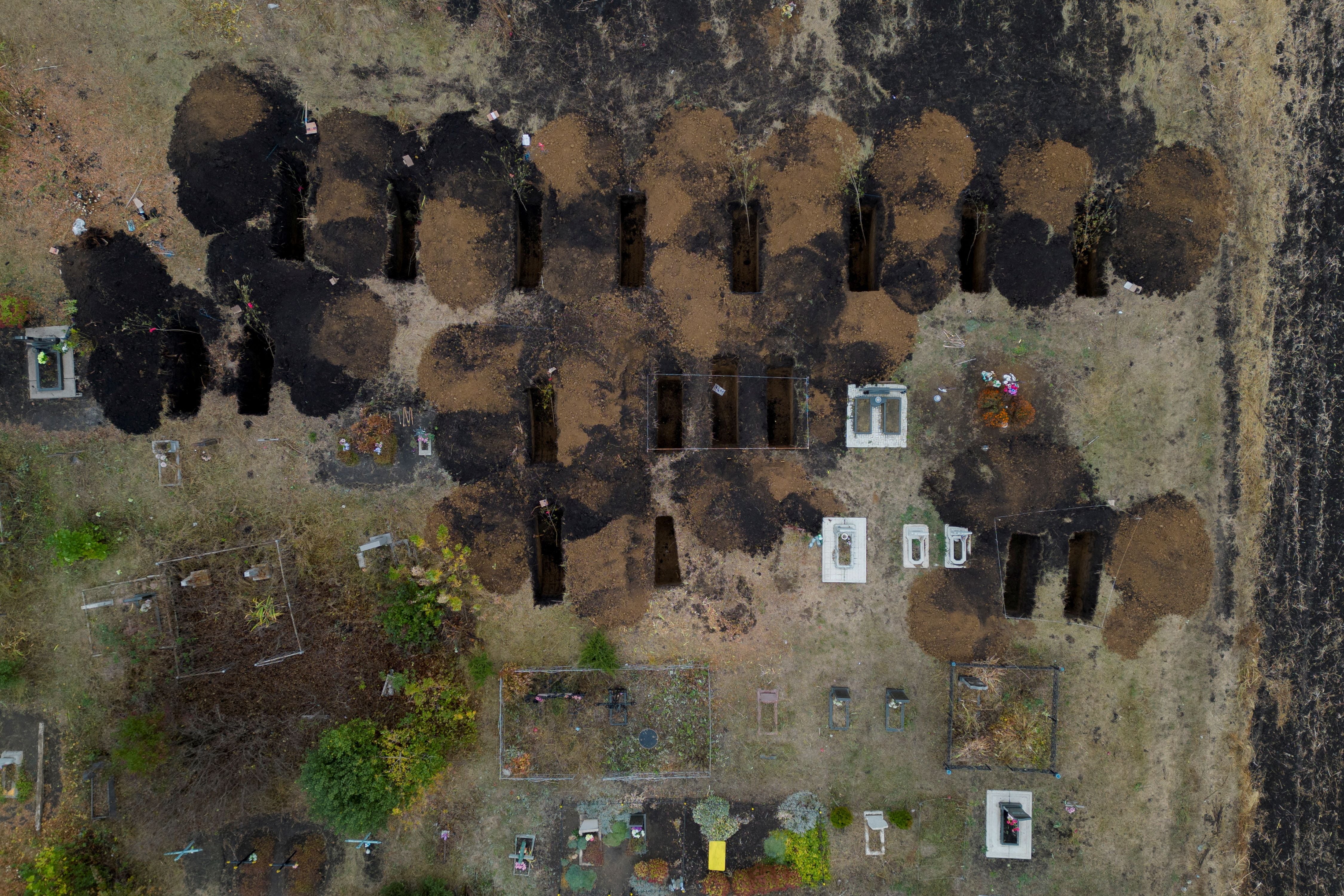 Una fotografía aérea muestra tumbas recién excavadas en el cementerio de la aldea de Hroza, cerca de Kharkiv, donde al menos 52 personas murieron en un ataque con misiles en medio del actual ataque de Rusia contra Ucrania, el 8 de octubre de 2023. REUTERS/Thomas Peter