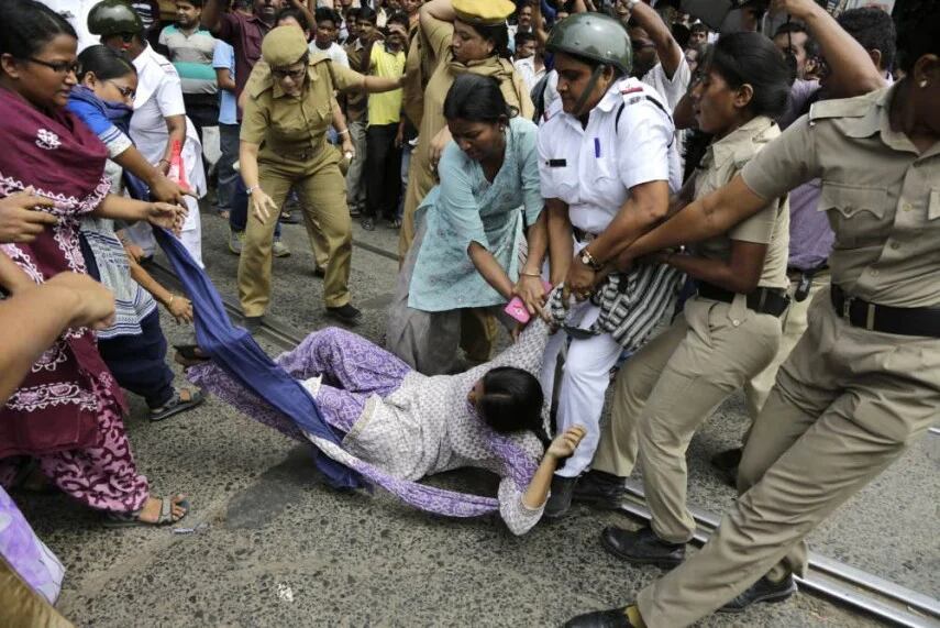Policías detienen a una activista feminista durante una protesta por una violación grupal en India (AP)