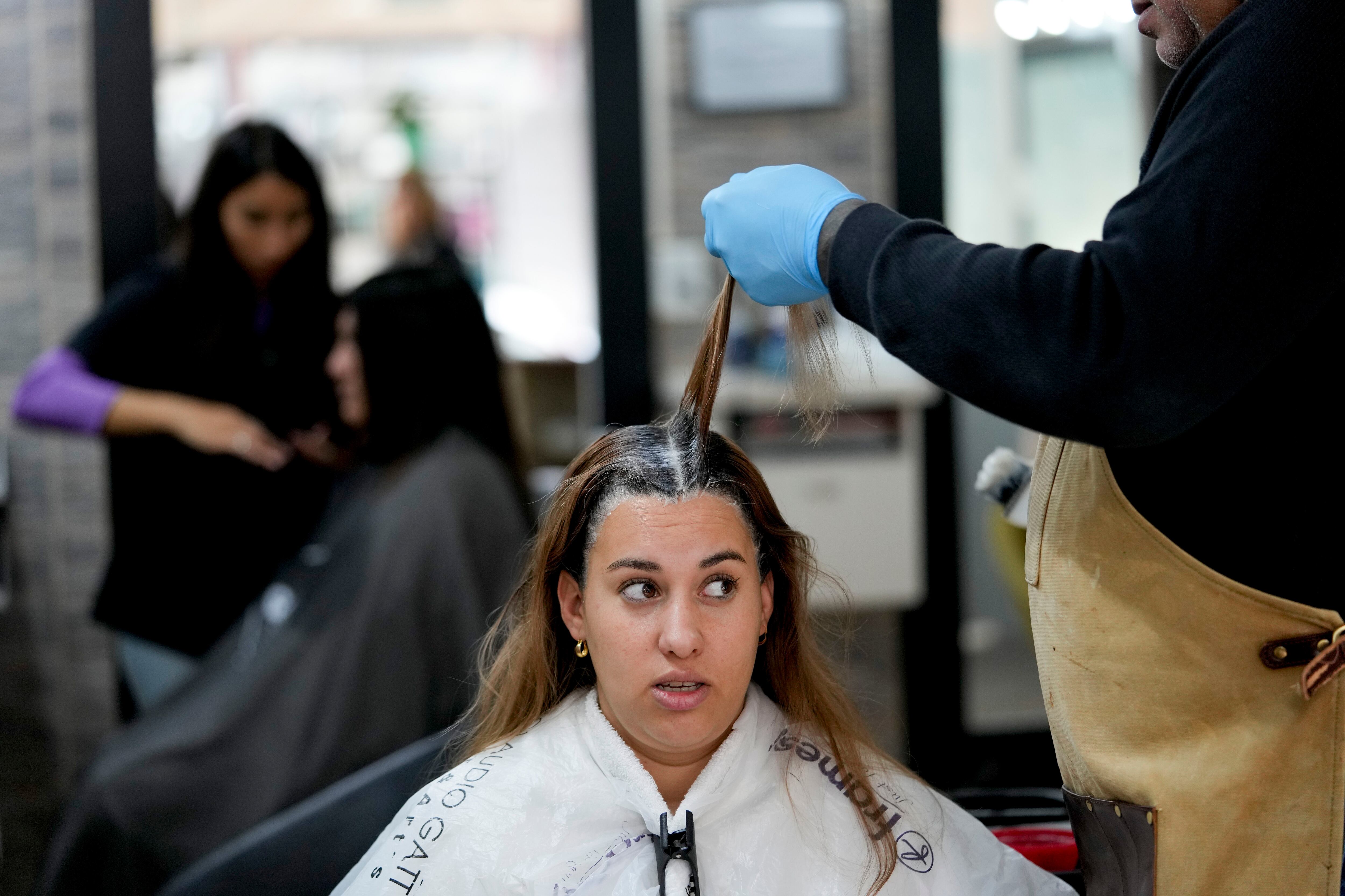 La uruguaya Stella Ferreira se hace teñir el pelo en un salón de belleza en Gualeguaychú, provincia de Entre Ríos, Argentina, cerca de la frontera con Uruguay, 30 de junio de 2023. Ferreira, de la ciudad uruguaya de Fray Bentos, a unos 45 kilómetros, había cruzado la frontera con tres amigas para ir de compras, aprovechando la ganga provocada por la caída del peso argentino frente al dólar. (AP Foto/Natacha Pisarenko)