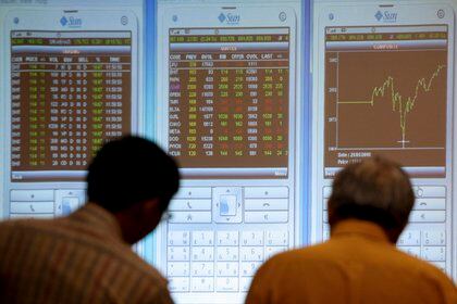 Dos inversores indonesios miran un tablero electrónico con índices de la bolsa de valores de Indonesia en Yakarta.  EFE / MAST IRHAM / Archivo