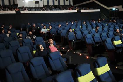 Grupos de personas con tapabocas asisten al cine este viernes, en San Jose (Costa Rica). EFE/ Jeffrey Arguedas
