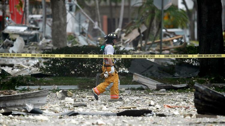 Un bombero camina entre los escombros después de la explosión de gas (AP Photo/Brynn Anderson)