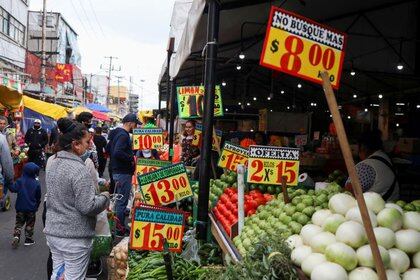 FOTO DE ARCHIVO. La gente mira carteles con precios de productos fuera de un mercado conocido como La Merced, ya que continúa el brote de la enfermedad por coronavirus (COVID-19), en Ciudad de México, México. 25 de junio de 2020. REUTERS/Henry Romero/File Photo