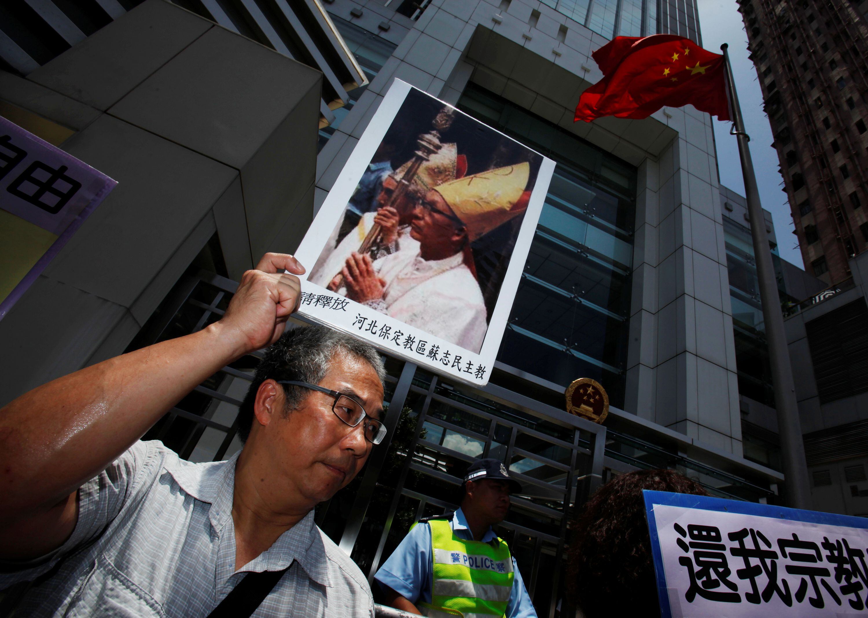 Un manifestante porta un retrato del obispo Su Zhi-ming de Baoding, provincia de Hebei, encarcelado en China y de quien se desconoce su paradero  (REUTERS/Bobby Yip)