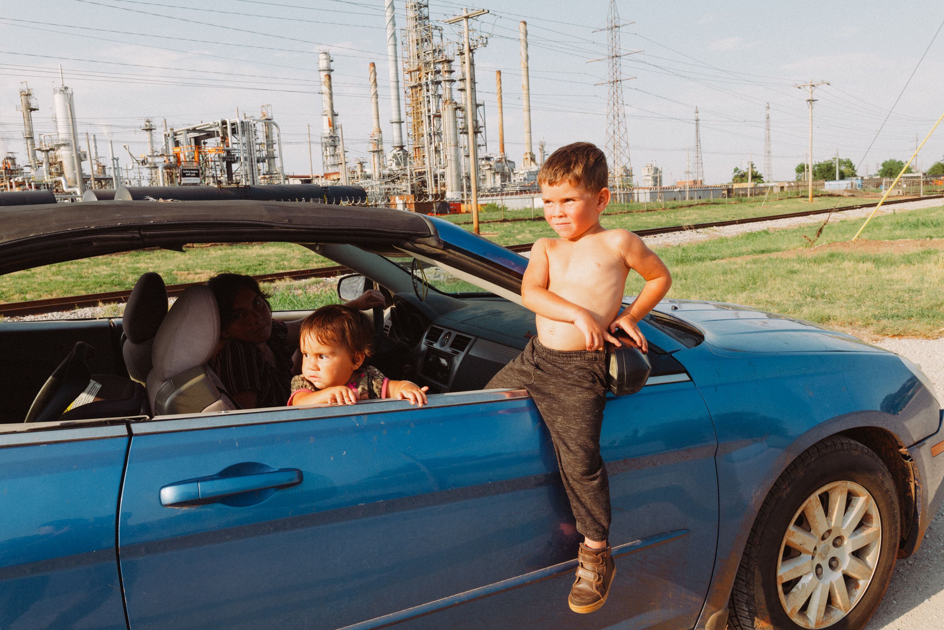 Unos niños esperan a su madre cerca de una refinería en Tulsa