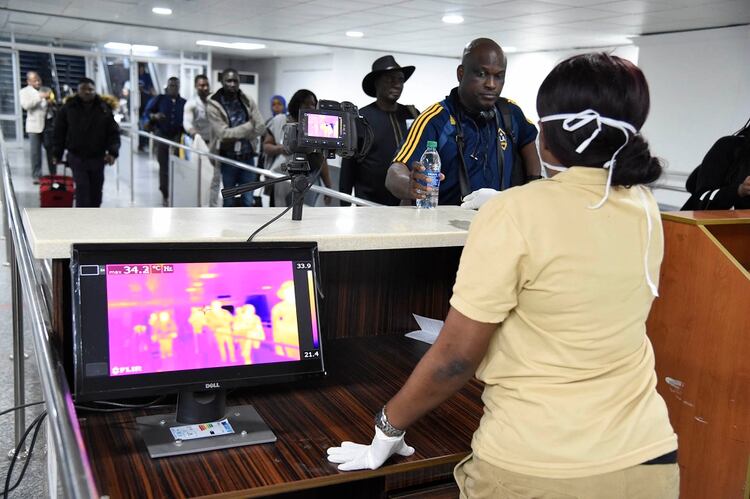 A los pacientes que llegan al aeropuerto de Nigeria se les toma la temperatura (Photo by PIUS UTOMI EKPEI / AFP)