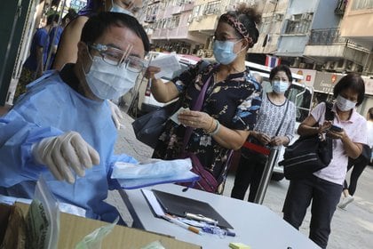 Personal médico de un centro hospitalario de Hong Kong atiende a un grupo de personas que se van a someter a la prueba de coronavirus (Europa Press)