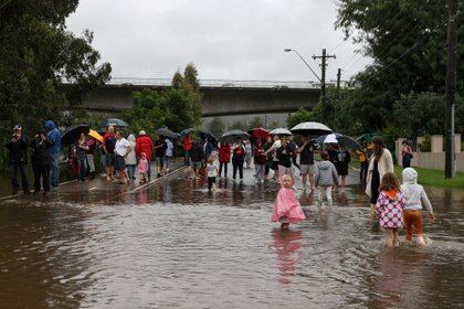 La gente se reúne en una calle residencial inundada cerca del crecido río Nepean. (REUTERS/Loren Elliott)