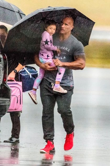 Dwayne Johnson -popularmente conocido como "La Roca"- fue visto junto a su esposa, Lauren Hashian, y sus hijos y la mascota de la familia bajando de su avión privado en Atlanta, Georgia. El actor protegió a una de sus hijas de la lluvia con un enorme paraguas mientras caminaba por la pista con la niña en brazos 