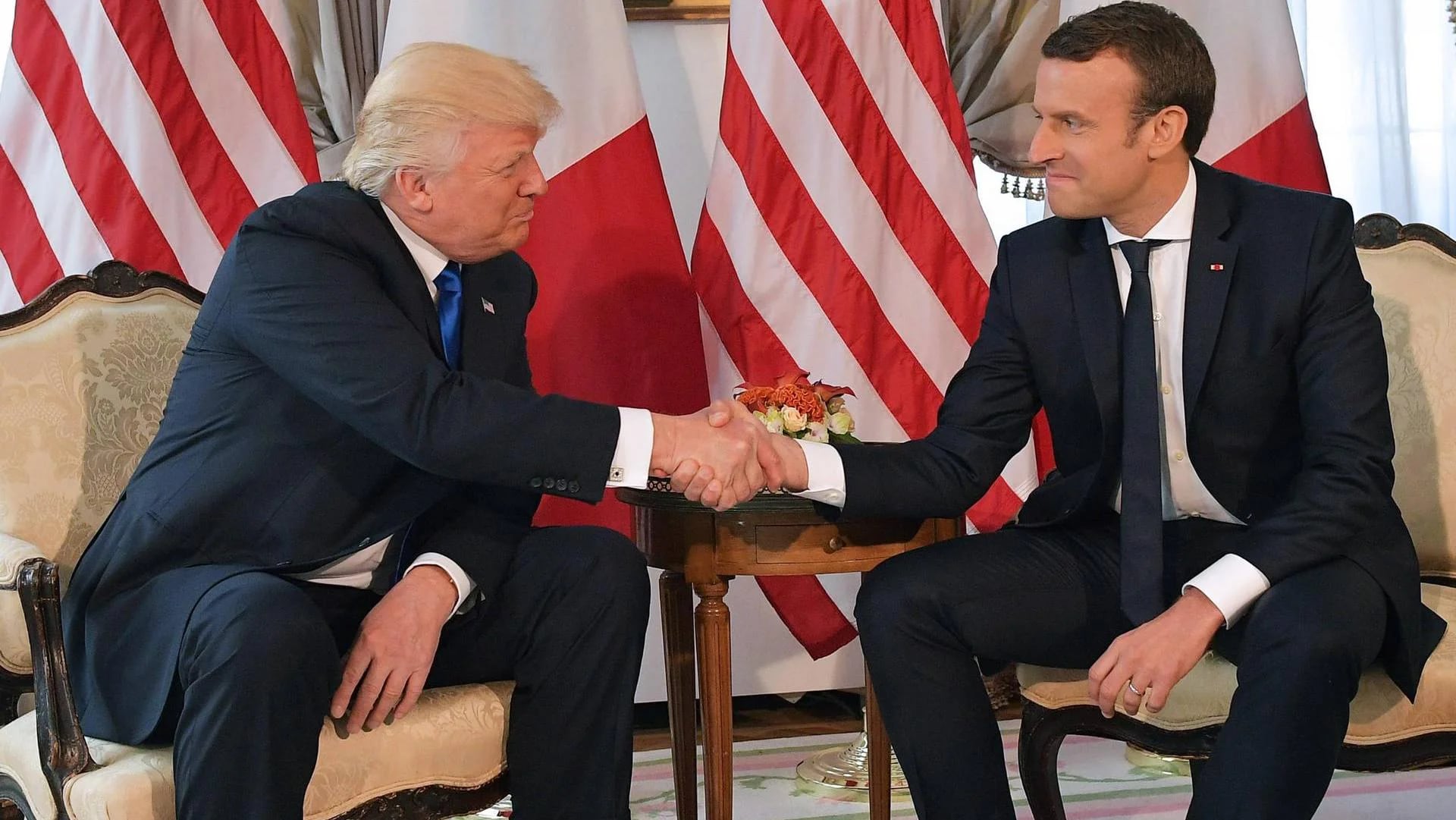 Donald Trump y Emmanuel Macron estrechan fuertemente las manos al inicio del encuentro (AFP)