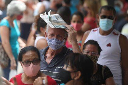 Personas utilizando mascarillas hacen fila para recibir la primera dosis de la vacuna CoronaVac contral el COVID-19, en Duque de Caxias, estado de Río de Janeiro, Brasil. Marzo 5, 2021. REUTERS/Pilar Olivares