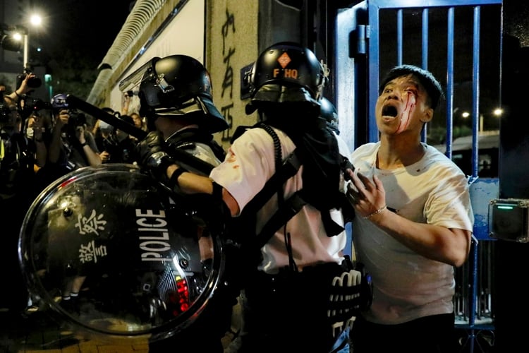 Un manifestante pide ayuda mientras es reprimido por la policía. (AP Photo/Vincent Yu)