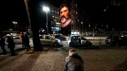 Napoli (Italy), 25/11/2020.- People pay tribute to former Argentinian soccer player and former Napoli player Diego Maradona near the Jorit mural in San Giovanni al Teduccio, a district of the eastern area of Naples, Italy, 25 Novembre 2020. Diego Maradona has died after a heart attack, media reports claimed on 25 November 2020. (Atentado, Italia, N�poles) EFE/EPA/CESARE ABBATE
