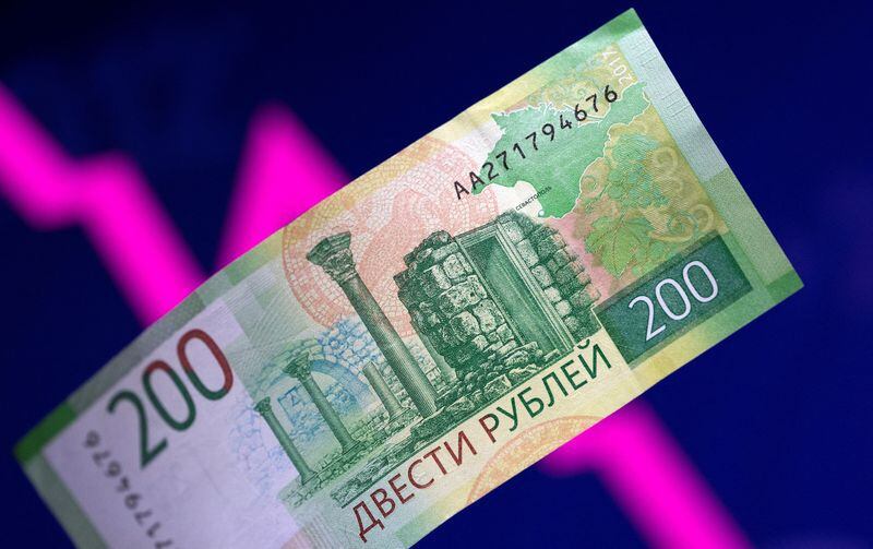 FILE PHOTO: A Russian ruble note is seen before a falling stock market chart in this illustration taken March 1, 2022. REUTERS/Dado Ruvic