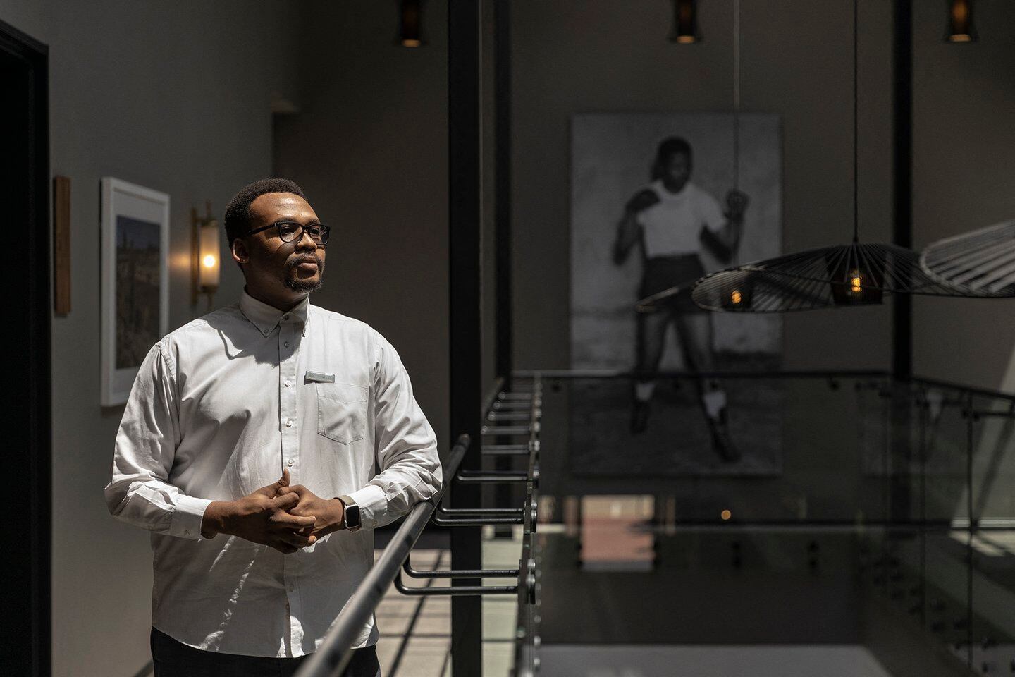 El director del hotel boutique Sanctuary Mandela, Dimitri Maritz, posa para un retrato junto a una imagen de la juventud de Mandela (Foto de GUILLEM SARTORIO / AFP)