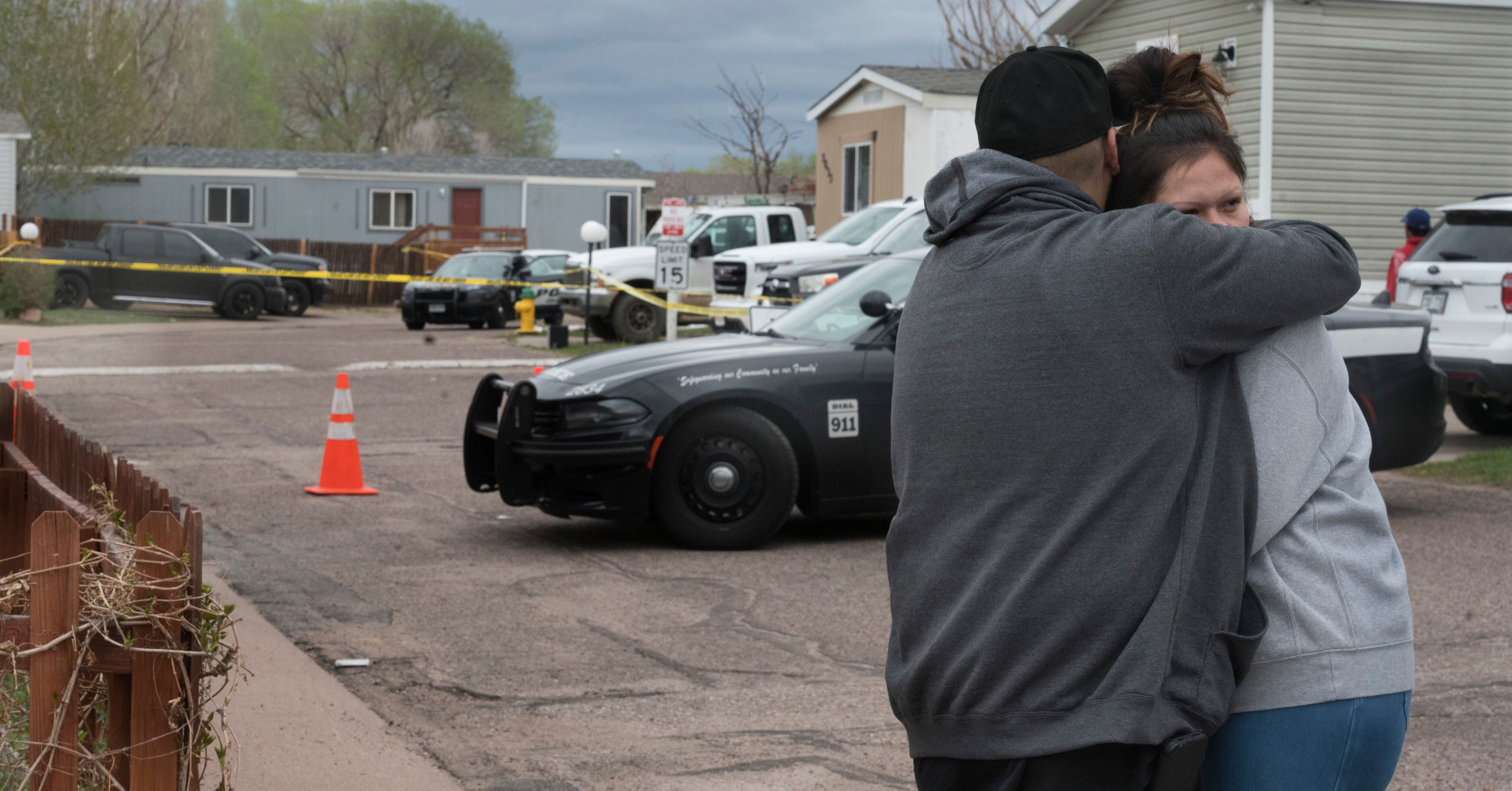 Familiares y amigos de las víctimas que murieron en un tiroteo, consuelan a cada uno en la calle de la escena en Colorado Springs.