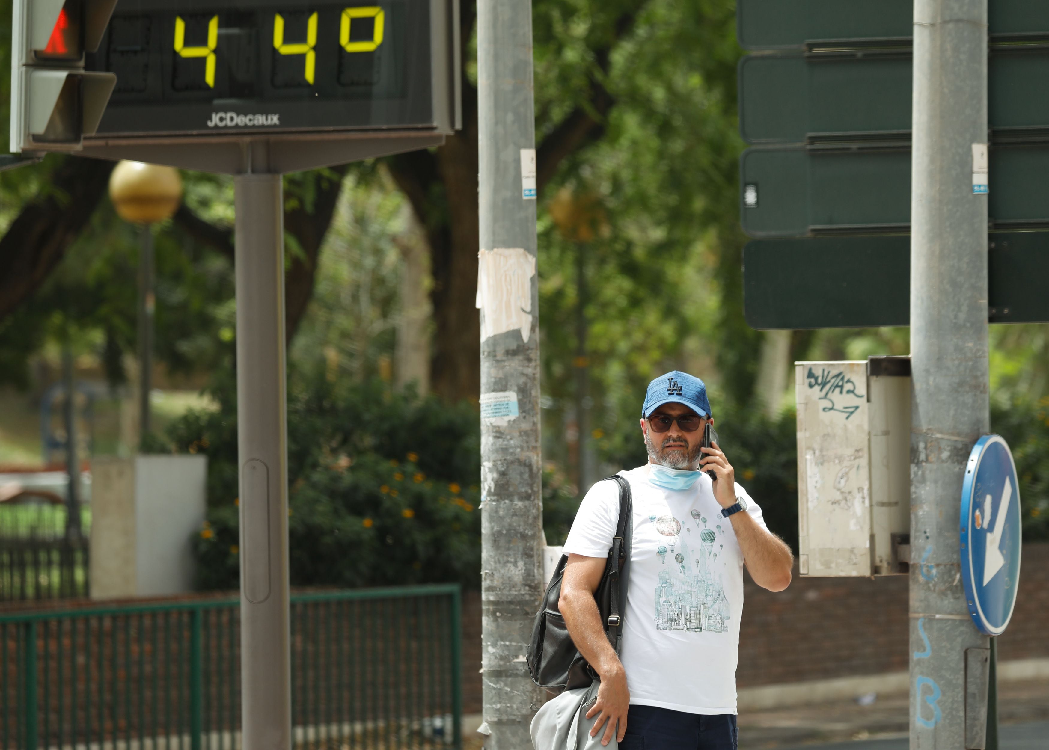 Un hombre habla por el móvil junto a un termómetro que marca 44º durante un día de alerta roja por altas temperaturas, en la ciudad de Murcia, Murcia (España). (Edu Botella - Europa Press)
